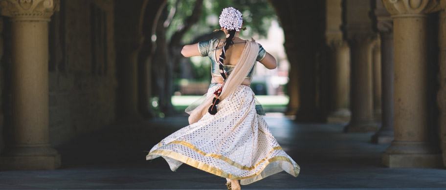 Egyptian danser clad in white with her back turned to the camera